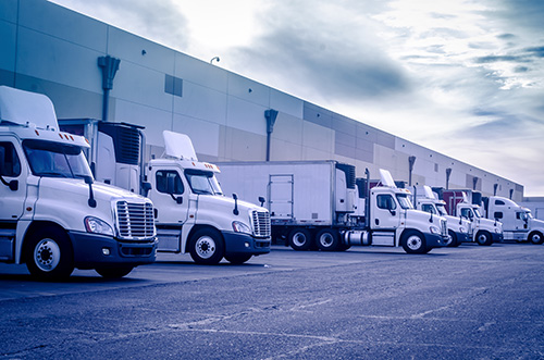 fleet of trucks parked at loading dock